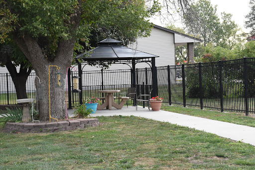 A peaceful backyard featuring a gazebo, surrounded by a fence and lush greenery.
