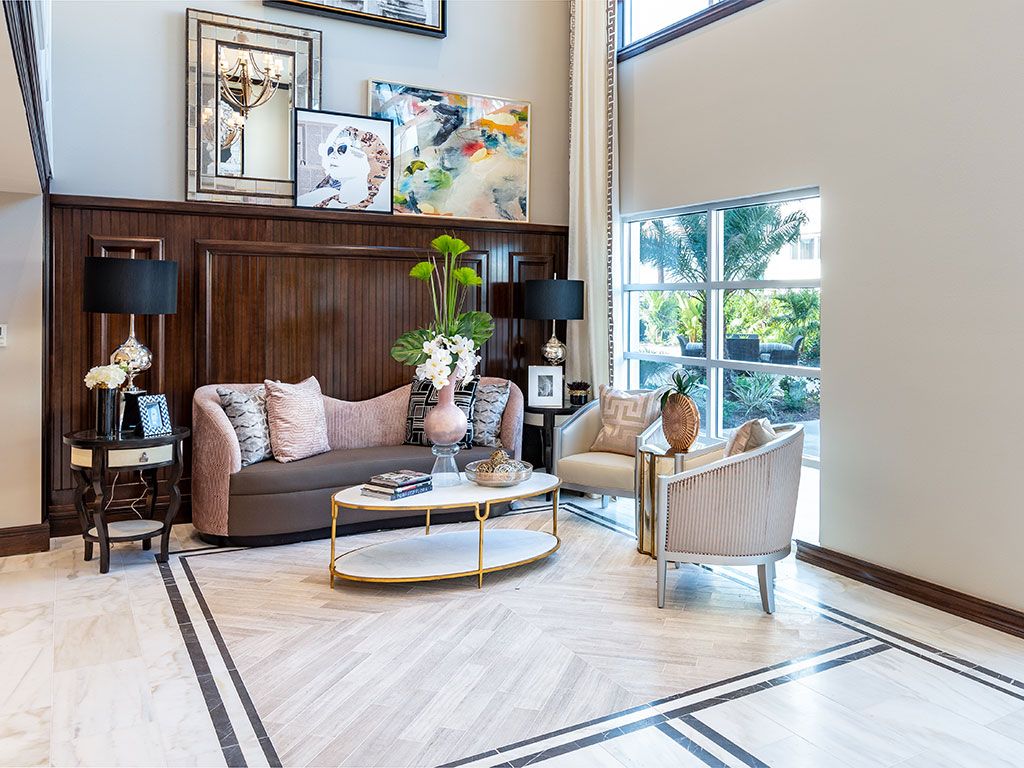 A stylish and modern living room with elegant furniture, decorative artwork, and ample natural light.