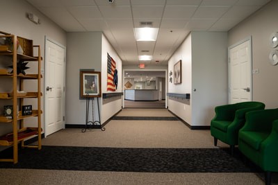 A modern hallway in an art gallery with paintings displayed along the walls.
