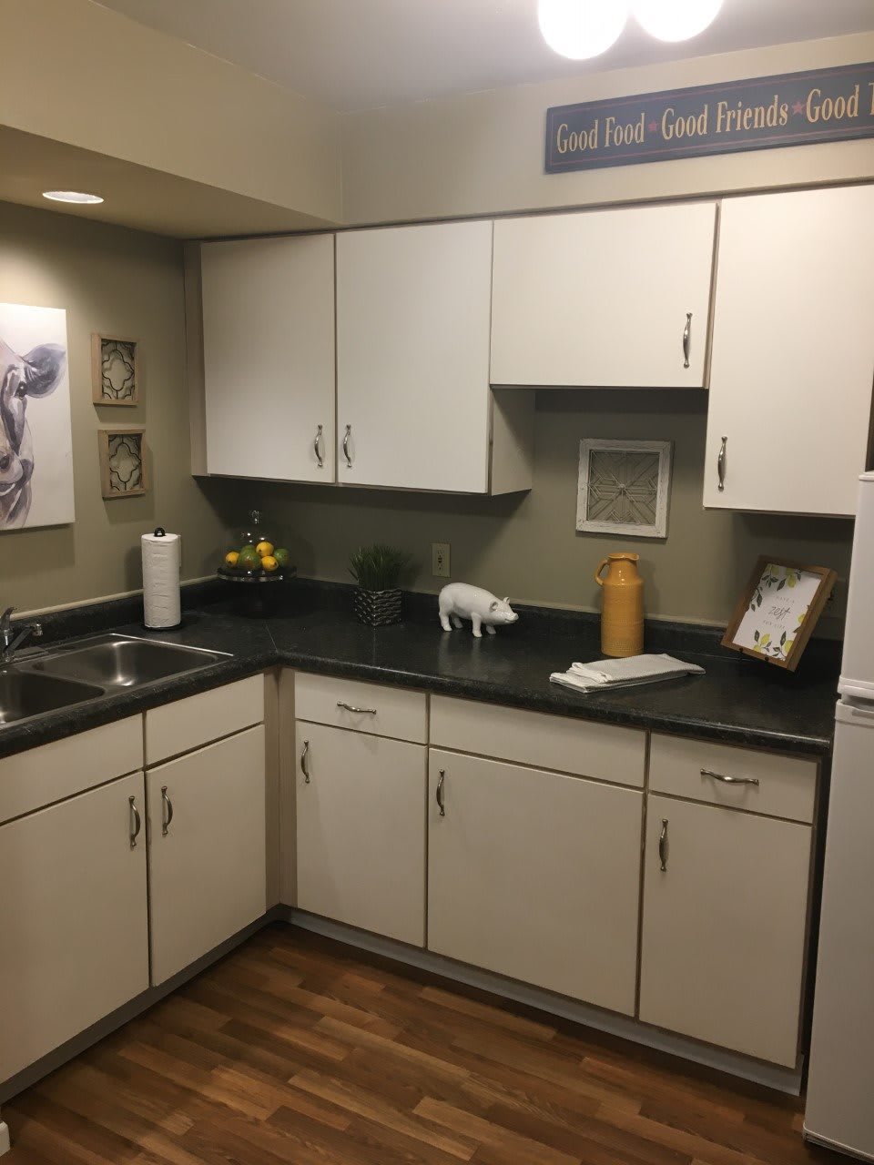 A modern kitchen with white cabinets and a dark countertop.