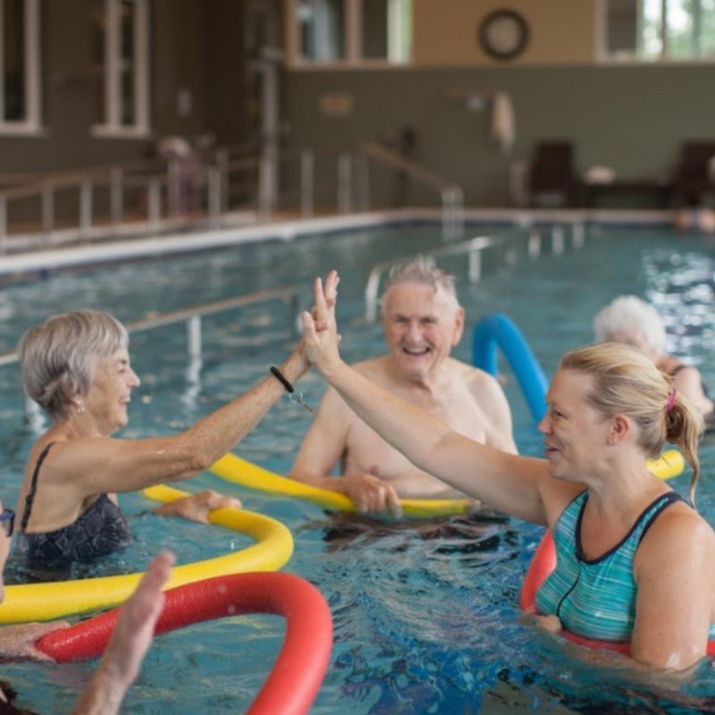 A group of senior citizens engaging in water aerobics in a swimming pool.