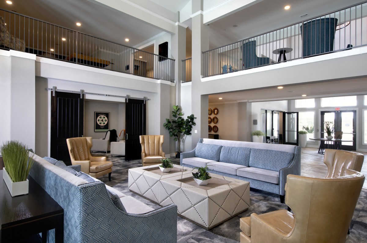 A spacious and modern living room with high ceilings, elegant furniture, and contemporary decor.