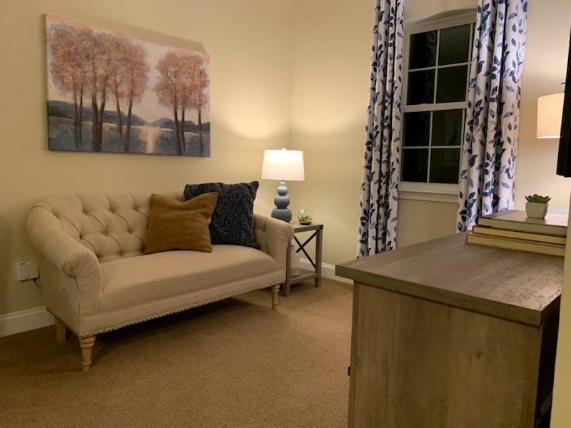A cozy living room with a sofa, soft lighting, and elegant decor.