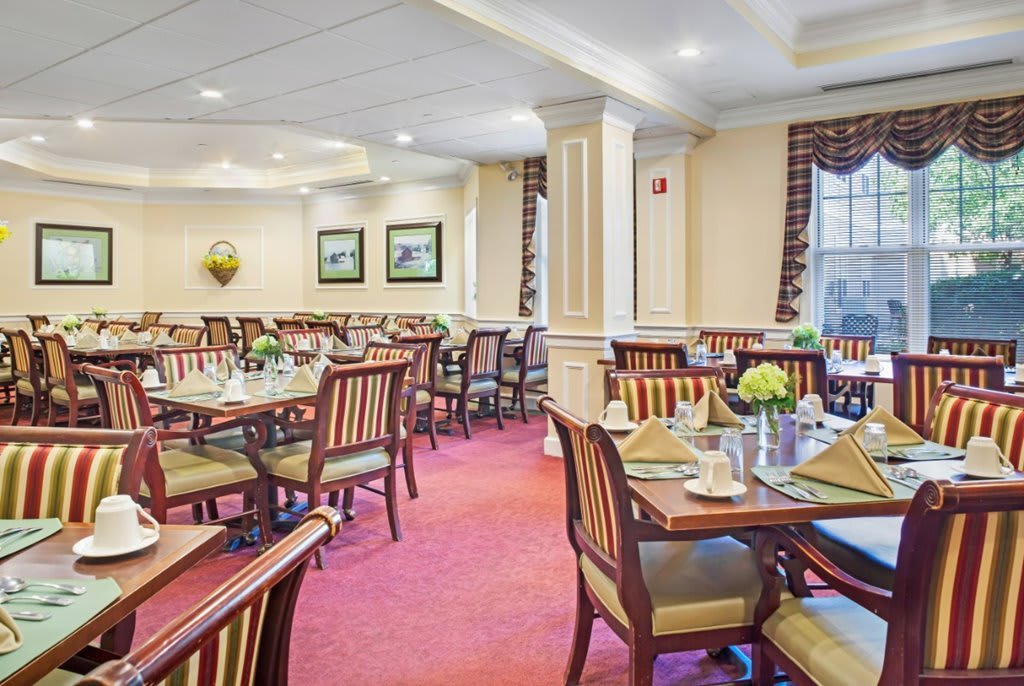 A formal dining room with neatly arranged tables and chairs.
