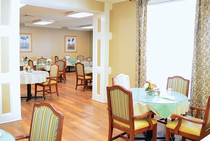 A well-lit dining area with neatly arranged tables and chairs.