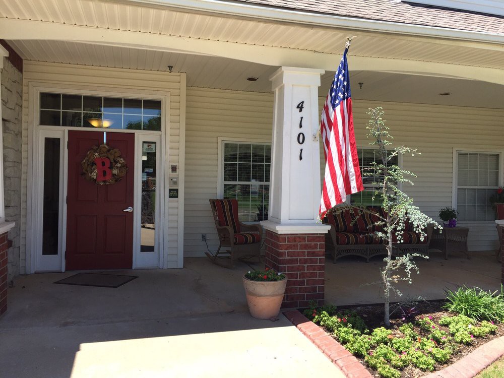 A cozy front porch with a red door and an American flag.