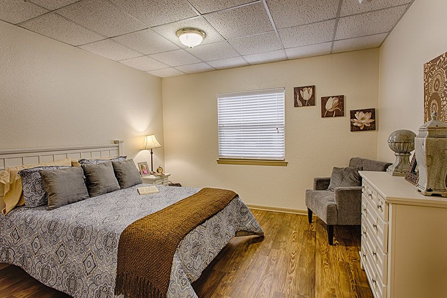 A cozy bedroom with a comfortable bed, bedside lamp, and decorative elements.