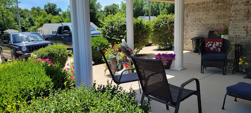 A peaceful outdoor patio setup, perfect for enjoying the sunshine and surrounding flowers.