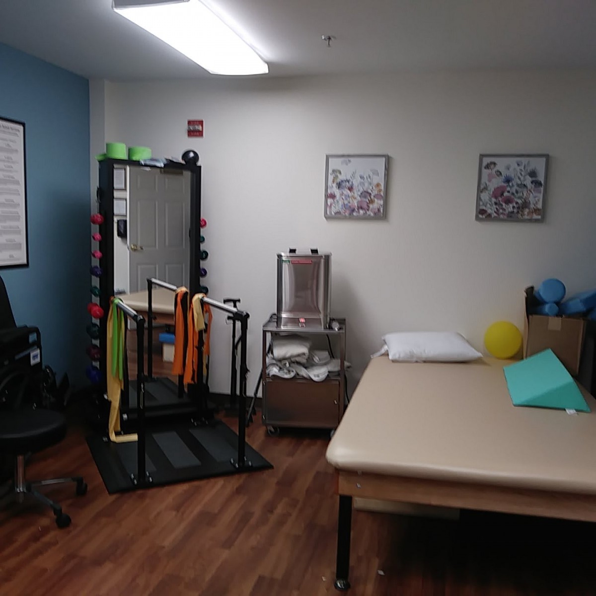 A well-organized physical therapy room with exercise equipment and a treatment table.
