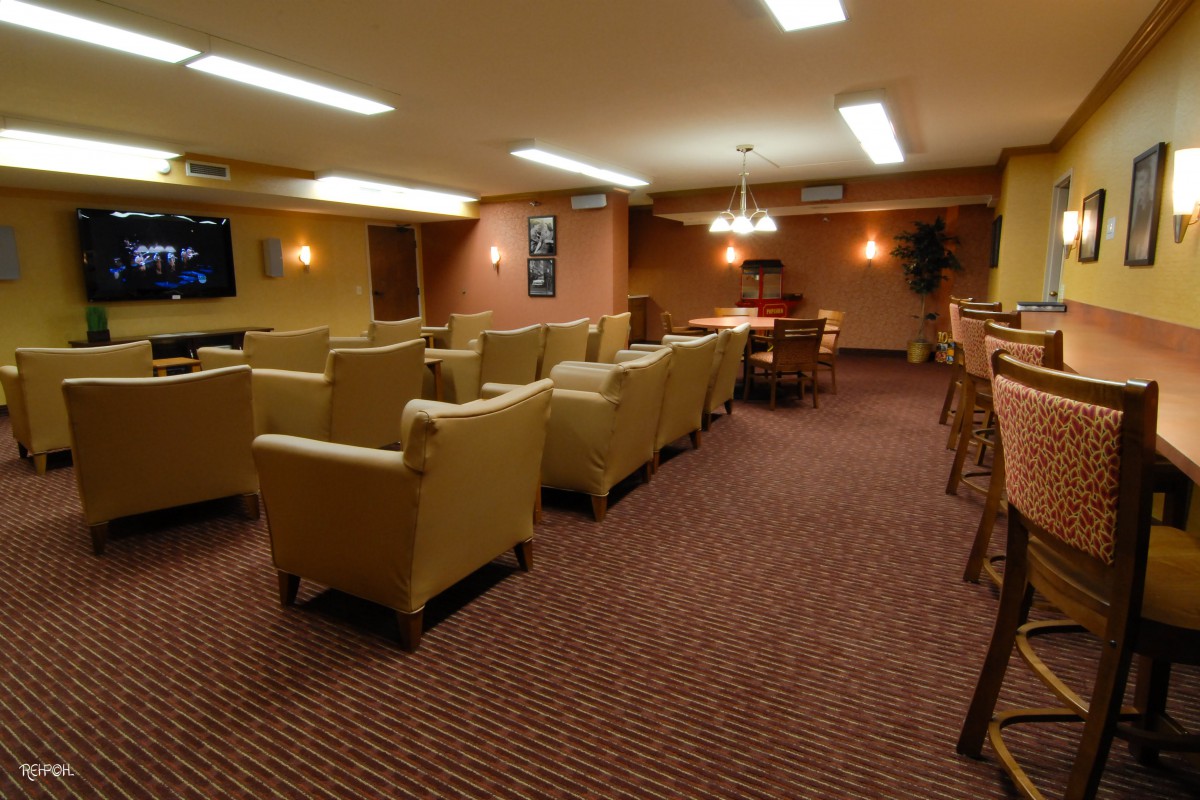 A cozy lounge area with comfortable seating and a large TV.