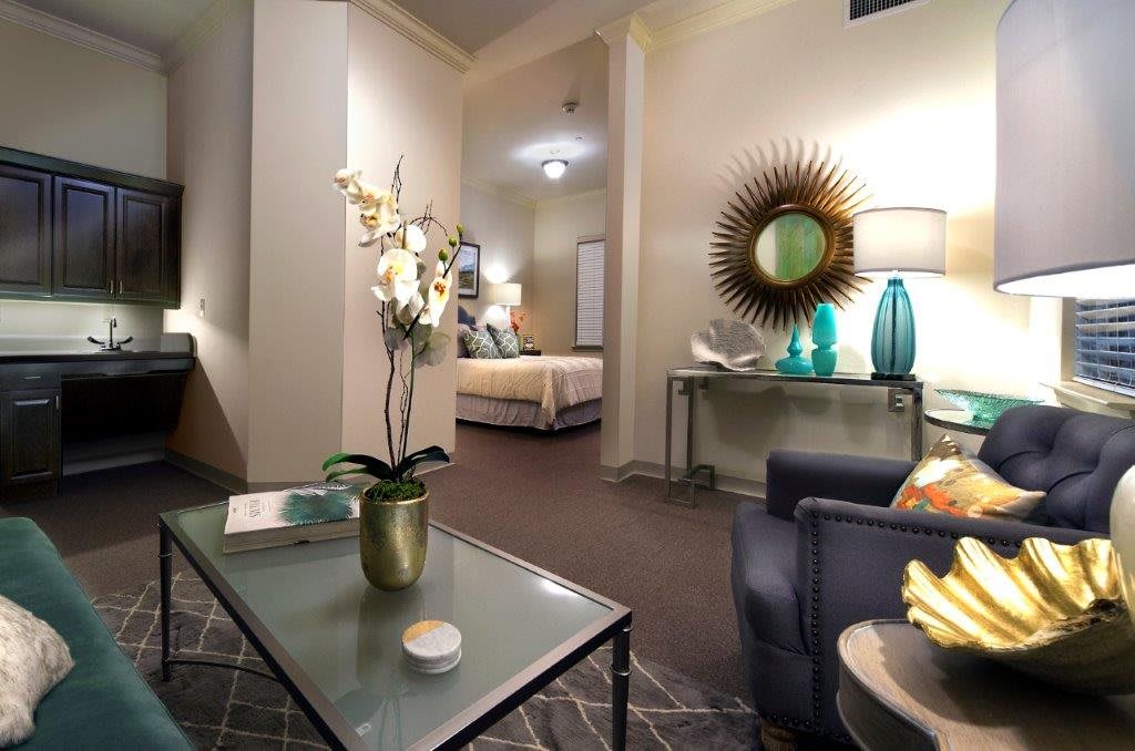 A modern living room with elegant decor and a view into a bedroom.