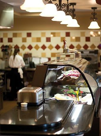 A deli counter in a restaurant with various meats and cheeses on display.