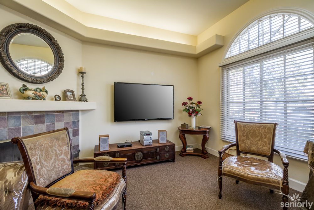 A cozy living room with elegant furniture and a mounted TV.