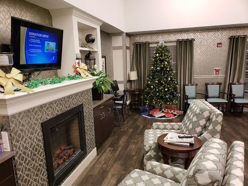 A cozy living room decorated for the holidays with a Christmas tree and a warm fireplace.