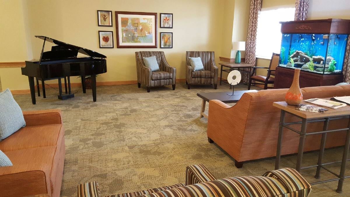 A cozy living room with comfortable seating and a piano.