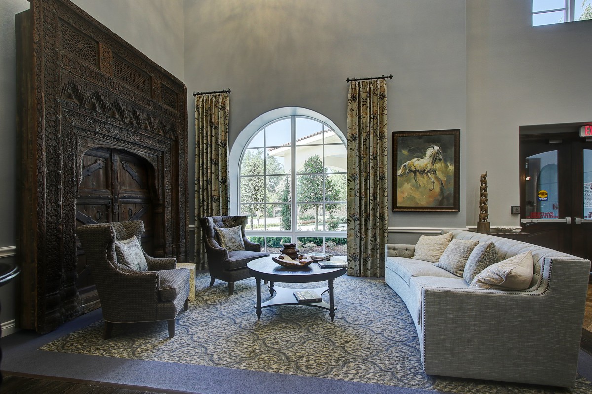 A beautifully designed living room with an arch window, sophisticated furnishings, and elegant decor.