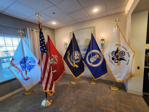 A display of military and national flags representing various branches of the U.S. Armed Forces.