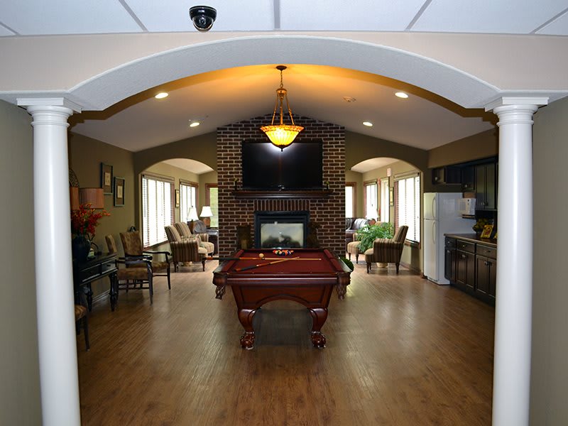 A stylish lounge area featuring a pool table, comfortable seating, and a television.