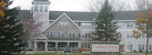 Exterior view of a residential building with a stone facade and signage.