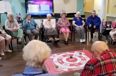 A group of elderly individuals participating in a social activity indoors.