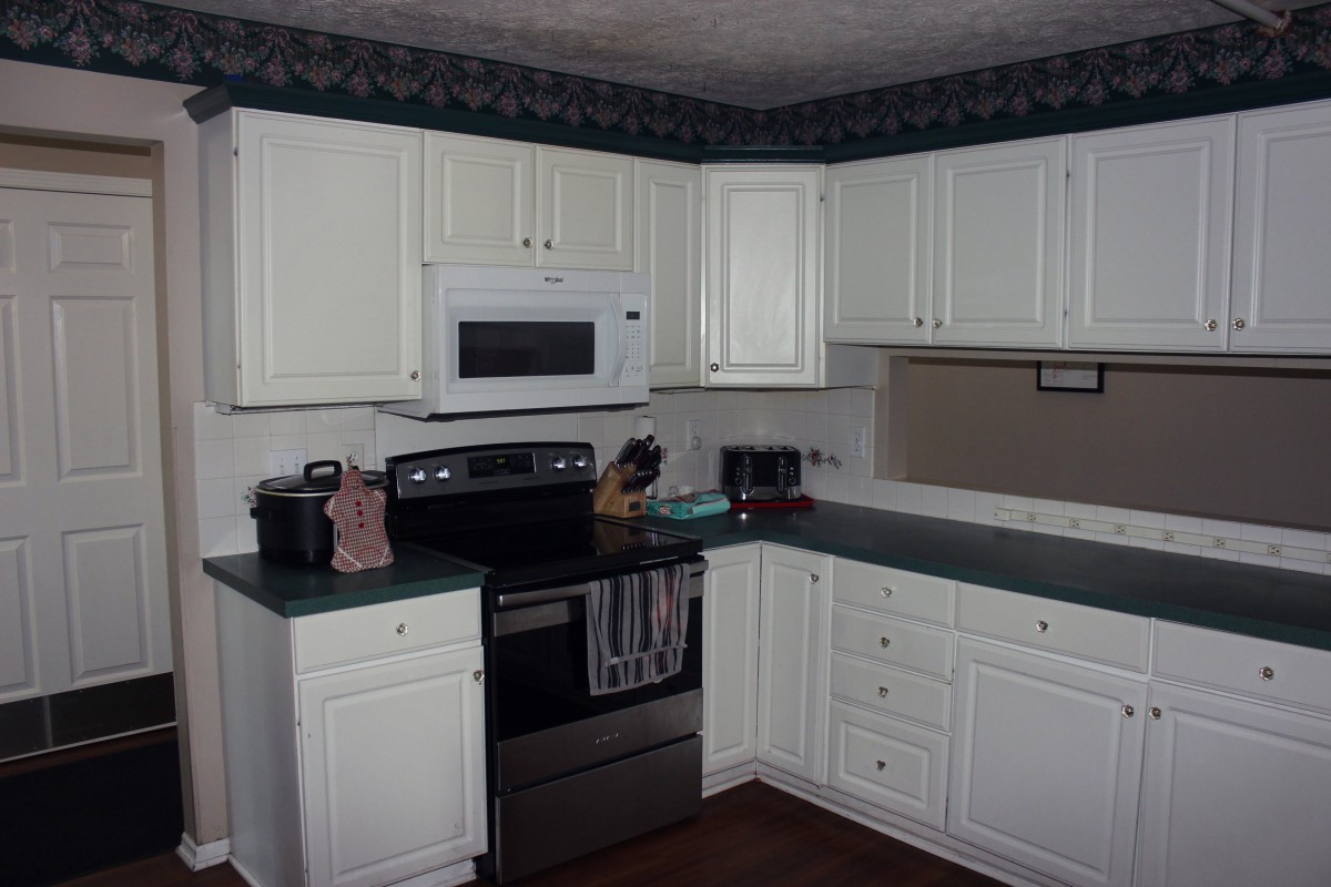 A neat and organized kitchen with white cabinets and modern appliances.