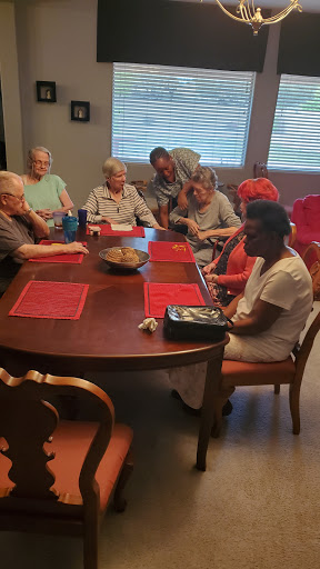 A group of seniors gathered around a table, engaging in conversation and activities.
