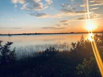 A tranquil sunset over the lake, reflecting the vibrant colors of the sky.