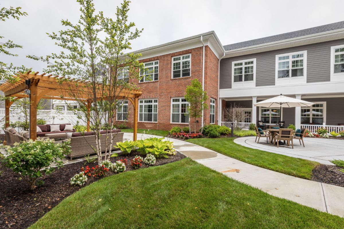 A well-maintained residential building with a landscaped garden and patio area.