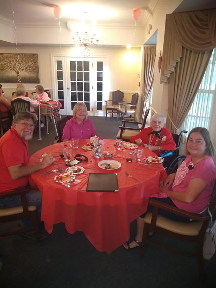 A group of people enjoying a meal together at a dining table indoors.
