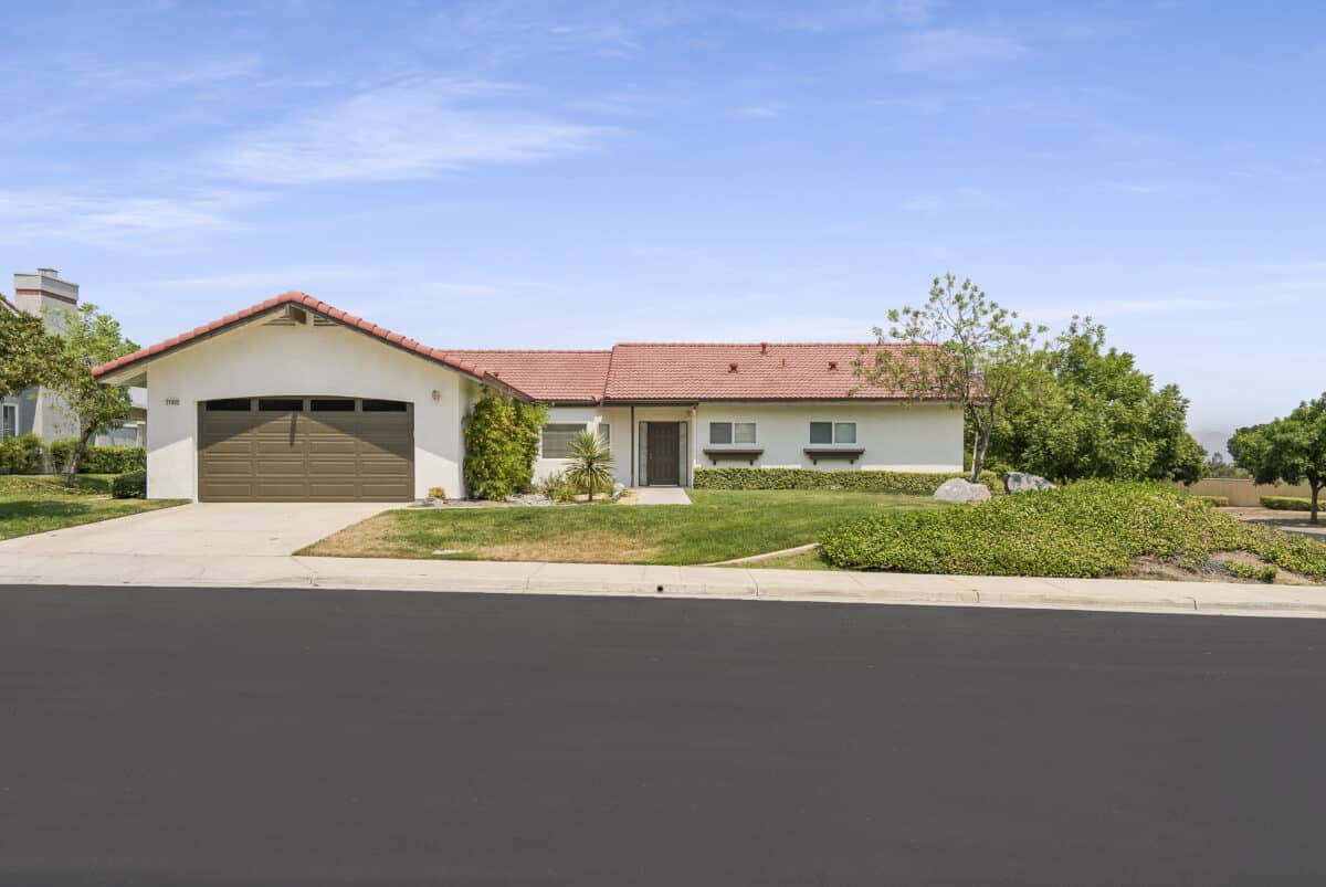 A single-story suburban house with a two-car garage and a well-maintained lawn.