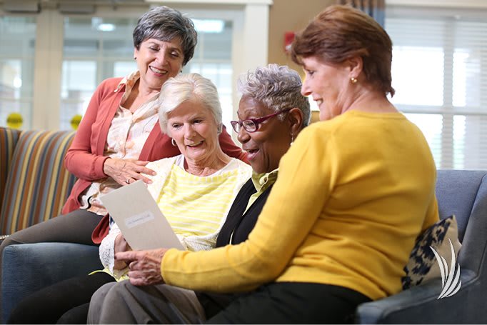 A group of seniors enjoying reading together in a community setting.