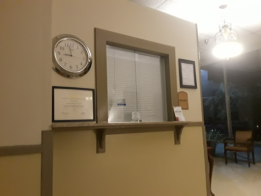 A cozy reception area featuring a clock and various certificates on the wall.
