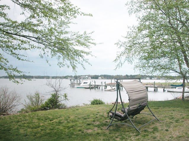 A peaceful lakeside view with a relaxing chair and dock.