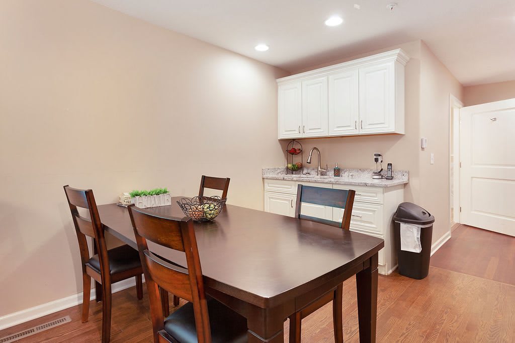 A modern dining area with a table and chairs adjacent to a kitchenette.