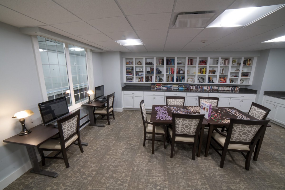 A modern office space with computers, tables, and chairs arranged for meetings.