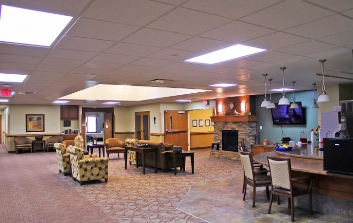 A modern communal lounge area with comfortable seating and a fireplace.