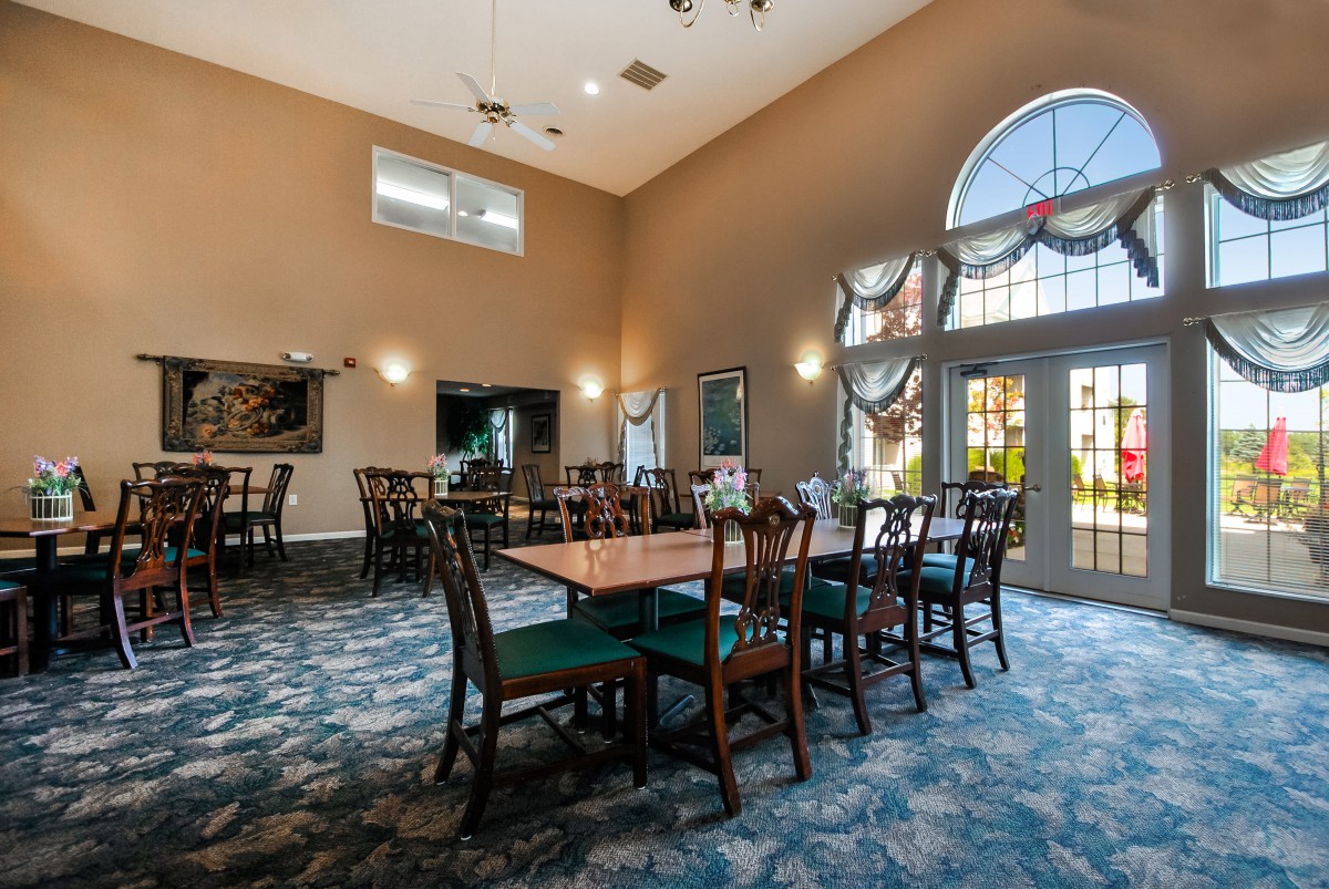 A spacious dining area with elegant furniture and large windows.