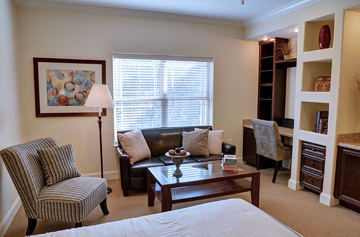 A cozy bedroom featuring a comfortable couch, a desk with a chair, and tasteful decor.