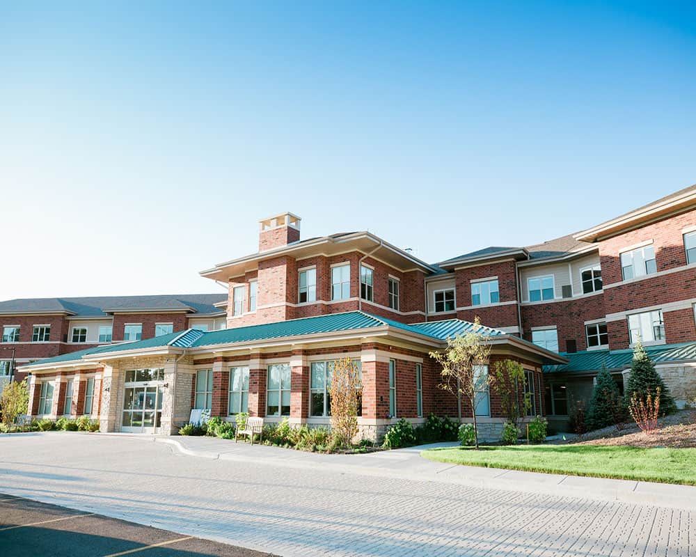A large brick building with multiple windows under a clear blue sky.