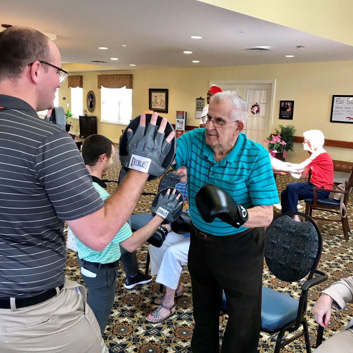 Seniors participating in a boxing exercise during a group activity session.