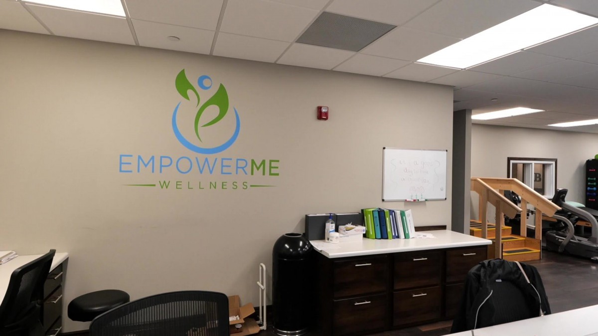 Reception area of a wellness center with a logo on the wall.