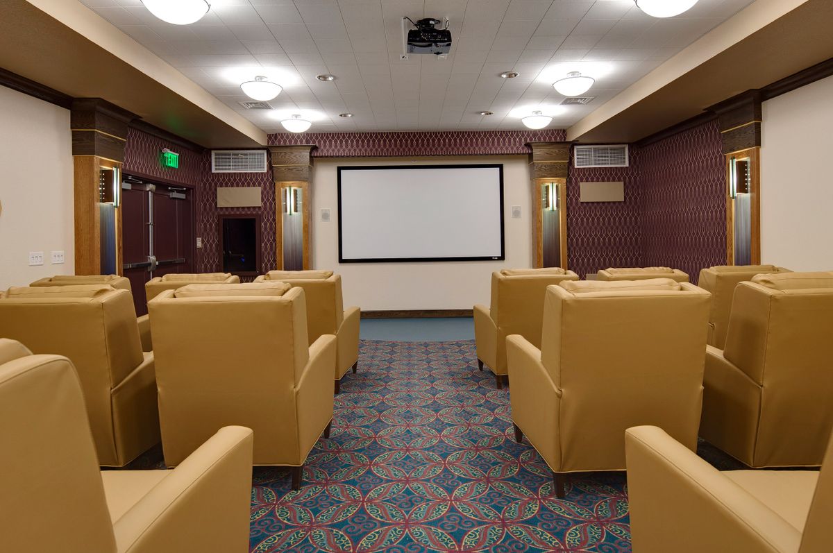 A cozy home theater setup with comfortable seating and a large projection screen.