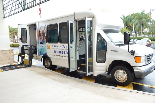 A shuttle van with a wheelchair lift being deployed.