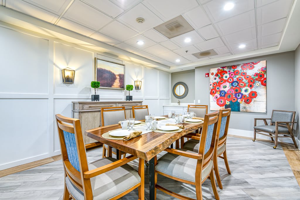 A modern and elegant dining room with a neatly set table and stylish artwork on the walls.