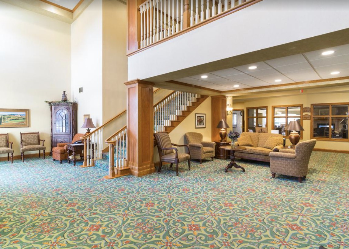 A spacious lobby interior with a seating area and staircase.