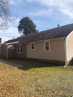 A single-story suburban house with a yard on a sunny day.