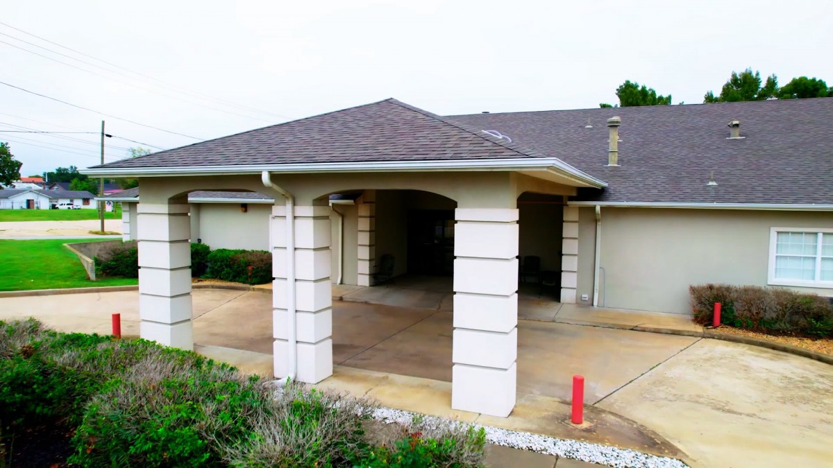 Suburban house with a covered driveway and columned entrance.