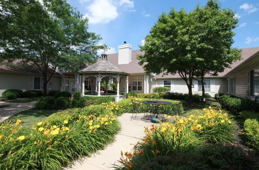 A beautiful garden with vibrant flowers and a gazebo on a sunny day.