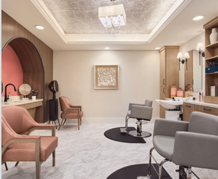 A modern and stylish salon interior featuring comfortable chairs and chic lighting.
