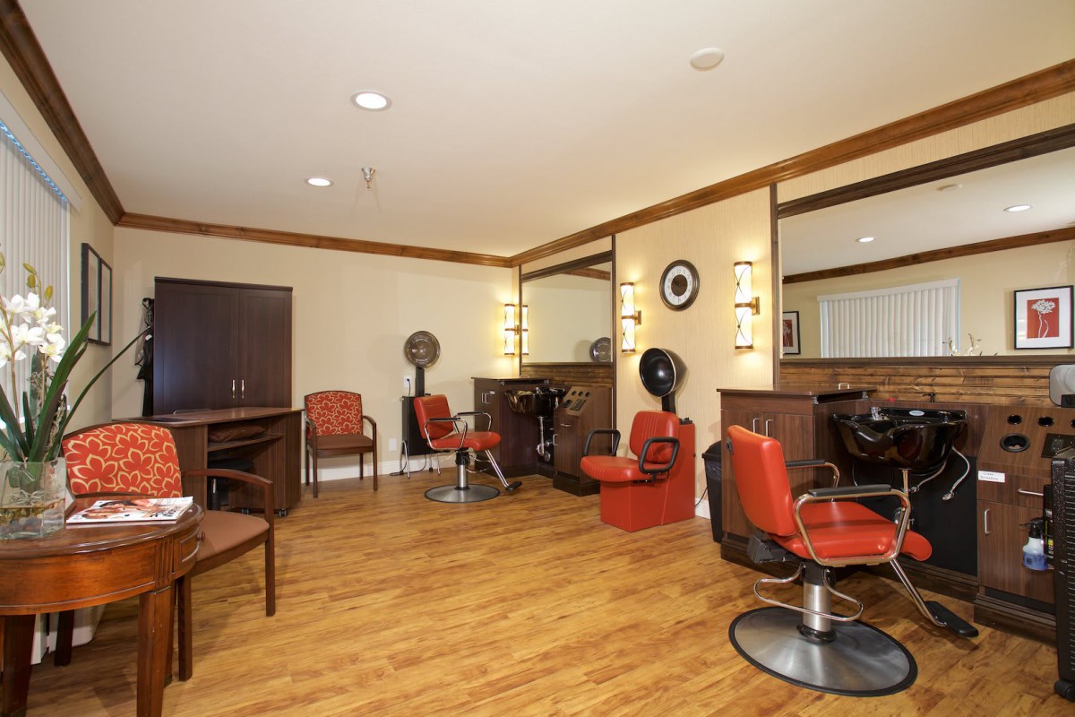 A modern hair salon with chairs, mirrors, and hair dryers, showcasing a clean and inviting interior design.